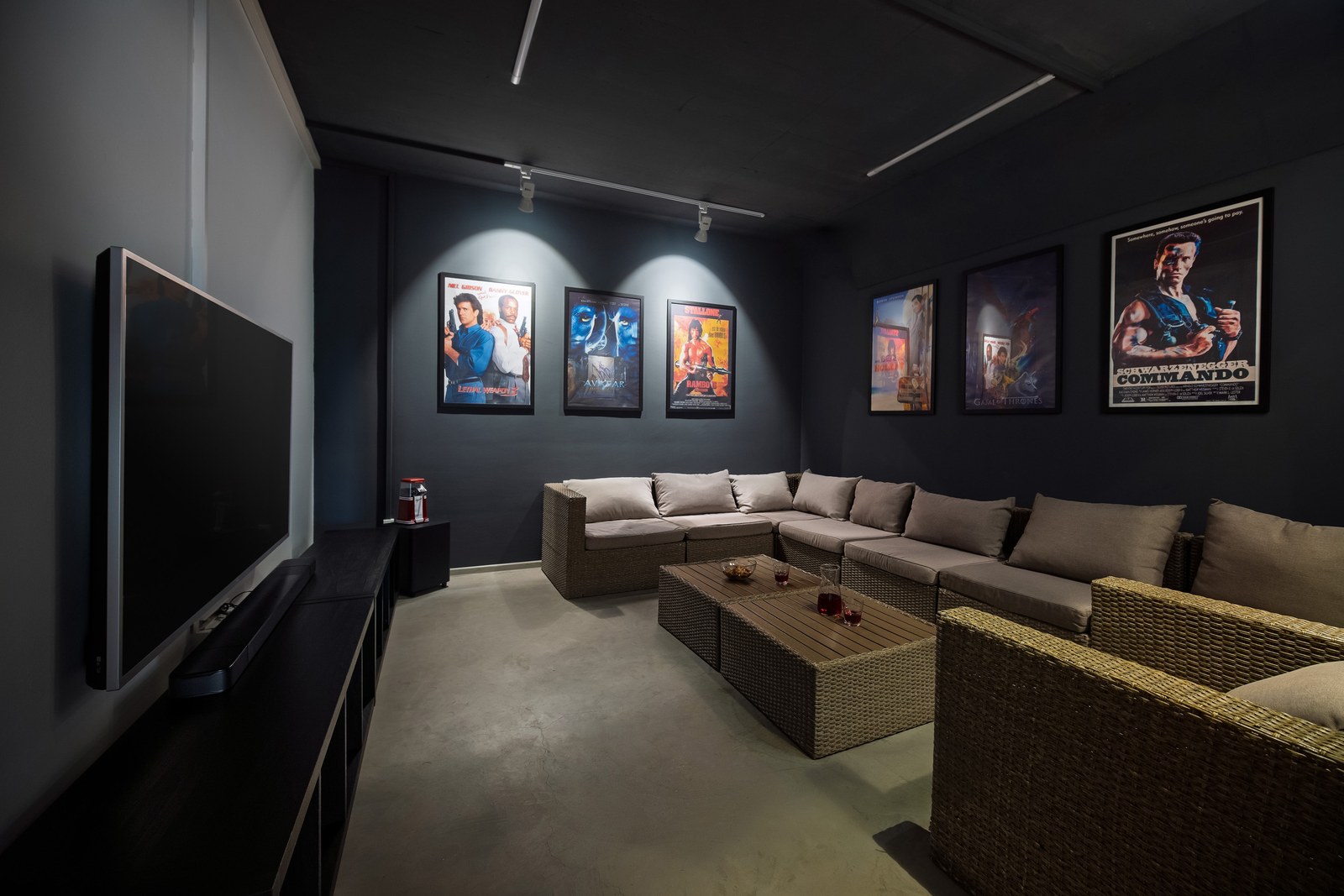 Private cinema lounge with a large television, corner sofa and film posters