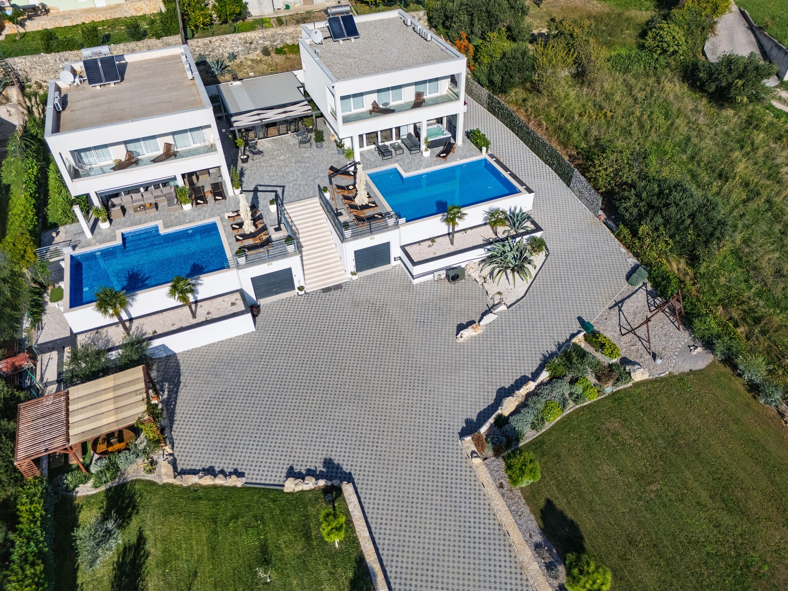 Aerial view of both villas, swimming pools, courtyard, lawns and garden pergola.